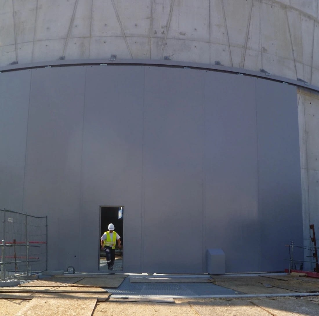 Puerta blindada corredera curva con puerta peatonal integrada en un hangar de pruebas de helicópteros